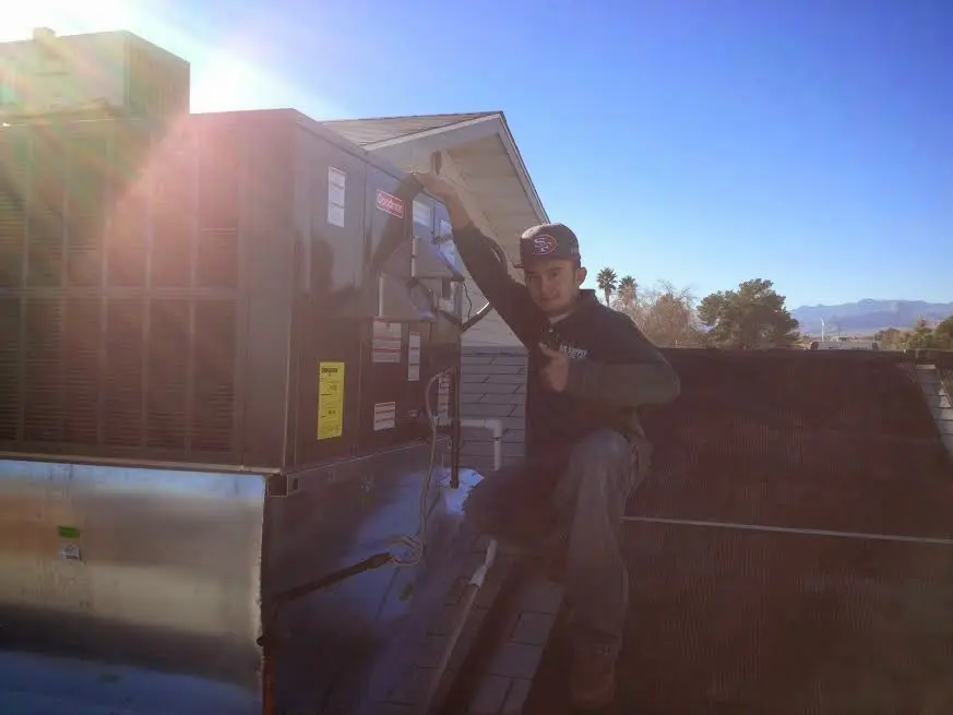 HVAC technician performing Air Duct Cleaning on a rooftop unit in Natchitoches